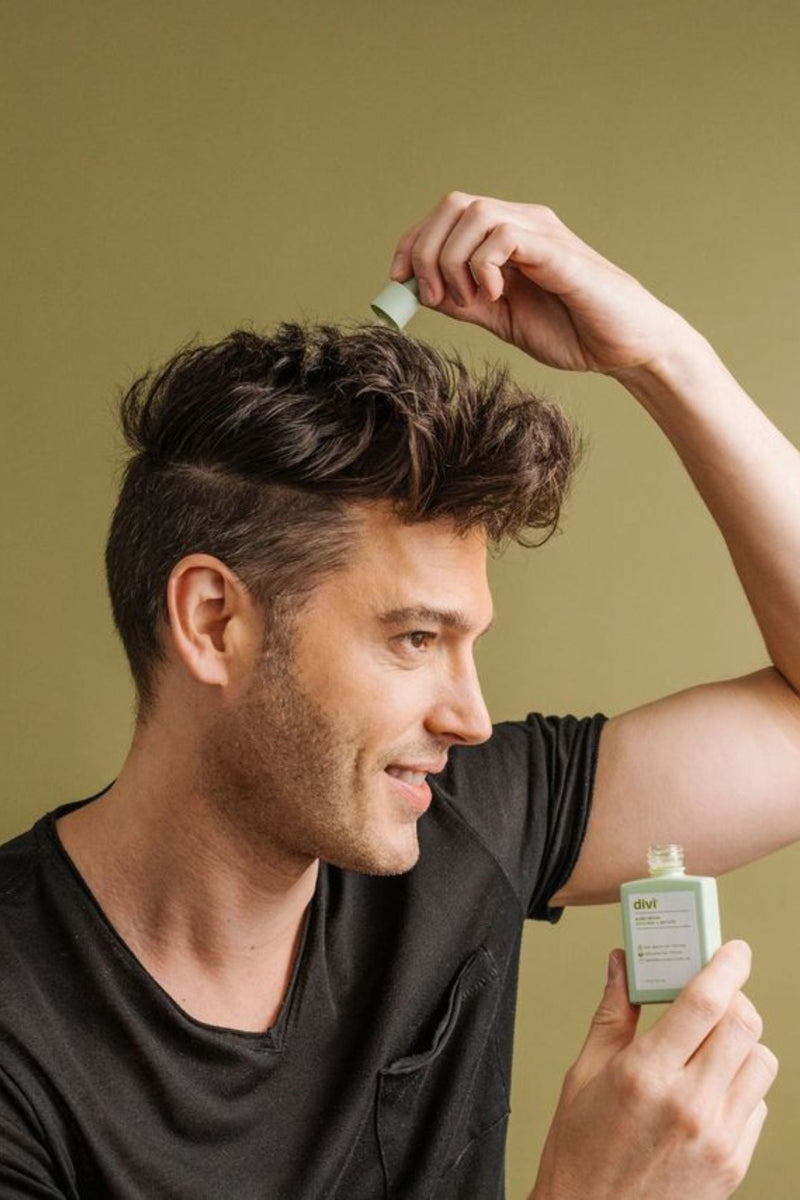 A man applying Divi's Scalp Serum on his scalp