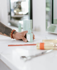 hair stylists hand putting divi product on the mirror counter